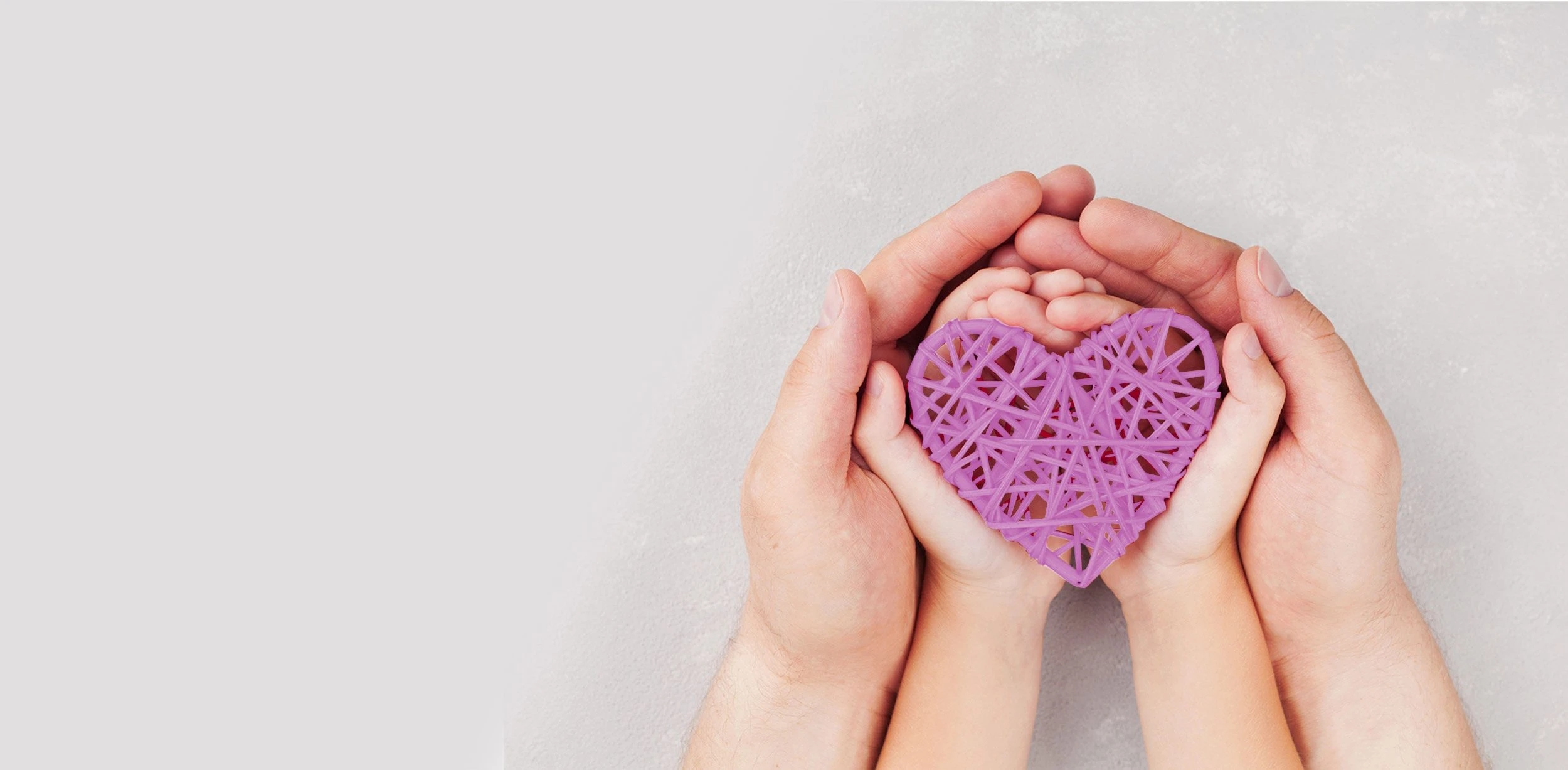 Manos de un adulto y de un niño sosteniendo un corazón